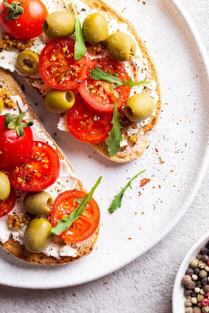 Bruschettas con aceitunas y tomates frescos y copa de vino