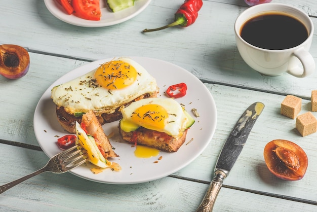 Bruschettas com legumes e ovo frito xícara de café e som