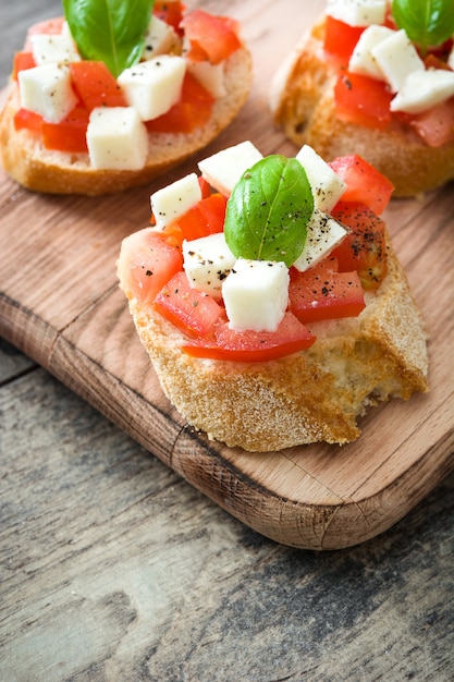 Bruschettas de ensalada Caprese aislado en mesa de madera