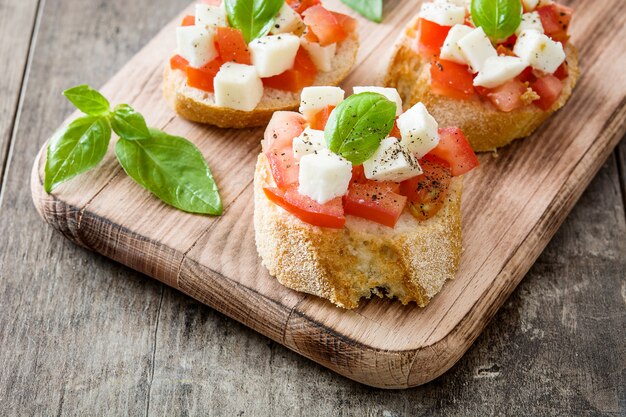 Bruschettas de ensalada Caprese aislado en mesa de madera