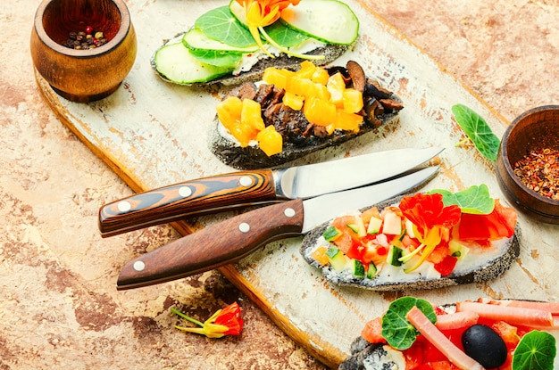 Bruschettas o crostini de verano con queso, tocino y verduras.