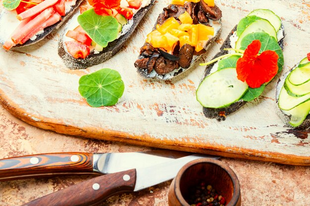 Bruschettas o crostini de verano con queso, tocino y verduras.