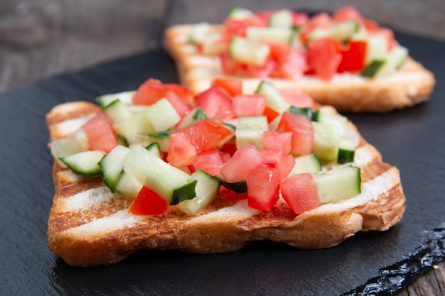 Bruschettas de pan tostado vegetariano con pepino fresco y tomate.