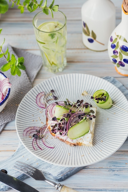 Bruschettas vegetarianas saudáveis com pão, micro verdes, queijo, pepino e cebola roxa