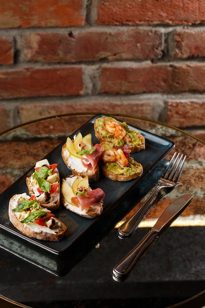 Bruschettas con verduras Platos de inicio con tomates cherry queso crema de aguacate y gambas Composición de alimentos sabrosa comida italiana