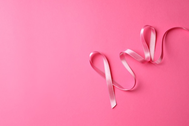 Brustkrebsbewusstseinsband auf rosa Hintergrund