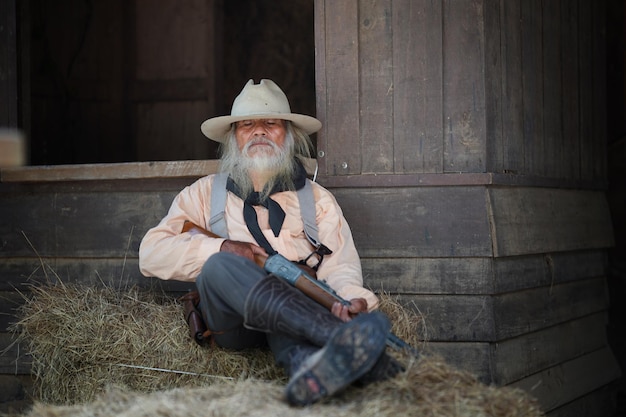 Brutal cowboy com a mão no revólver oeste selvagem