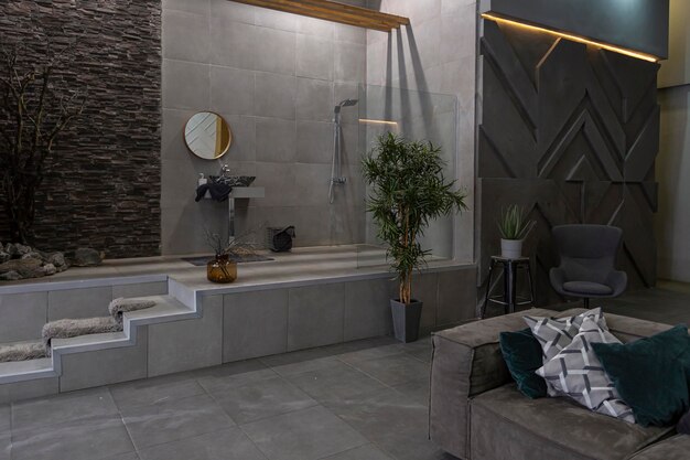 Brutal diseño interior ultra moderno de un apartamento de planta abierta con una ducha abierta decorada con piedra gris