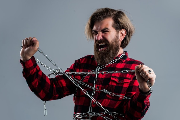 Brutal hombre barbudo en camisa a cuadros chico maduro con barba y bigote hombre mantenga cadena hipster guapo con gritos cara poder y fuerza concepto encarcelamiento Haga su elección