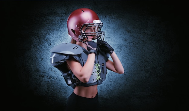 Brutal retrato de una niña con el uniforme de un jugador del equipo de fútbol americano. Publicidad de equipos. Concepto deportivo. Hombreras. Técnica mixta