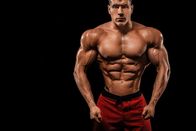 Brutal starker Muskel-Bodybuilder-Athlet Mann pumpt Muskeln auf schwarzem Hintergrund Workout-Bodybuilding-Konzept Kopieren Sie Platz für Sport-Nährstoff-Werbung