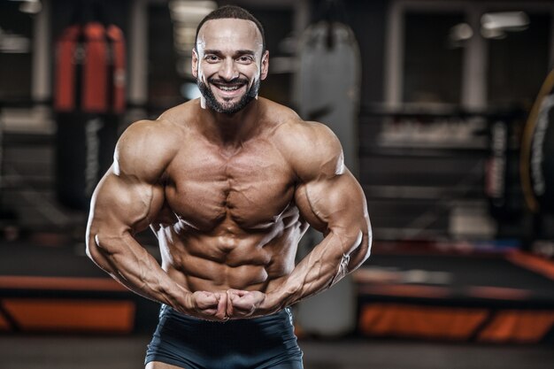 Brutale starke sportliche Bodybuilder-Männer, die Muskeln mit Hanteln aufpumpen