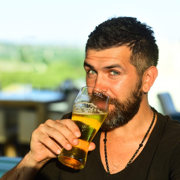 Brutaler bärtiger Hipster-Mann sitzt am Bartresen Hipster entspannt sich im Pub Mann hält ein Glas Bier