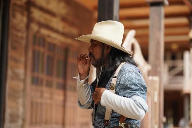 Brutaler Cowboy mit Revolver-Schießerei auf Texas-Ranch-Western Vintage männliche Person mit Waffe Wild-West-Lebensstil