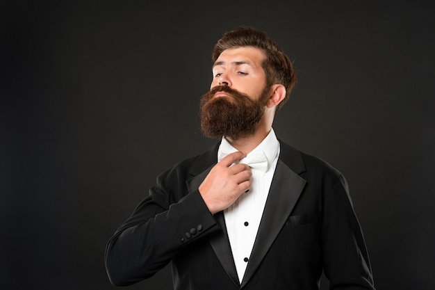 Brutaler Gentleman im Smoking auf schwarzem Hintergrund, Anzug