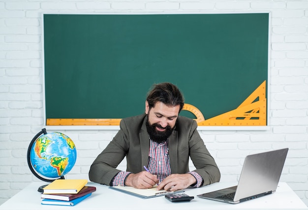 Brutaler unrasierter Universitätsdozent im Klassenzimmer, Lehrertag.