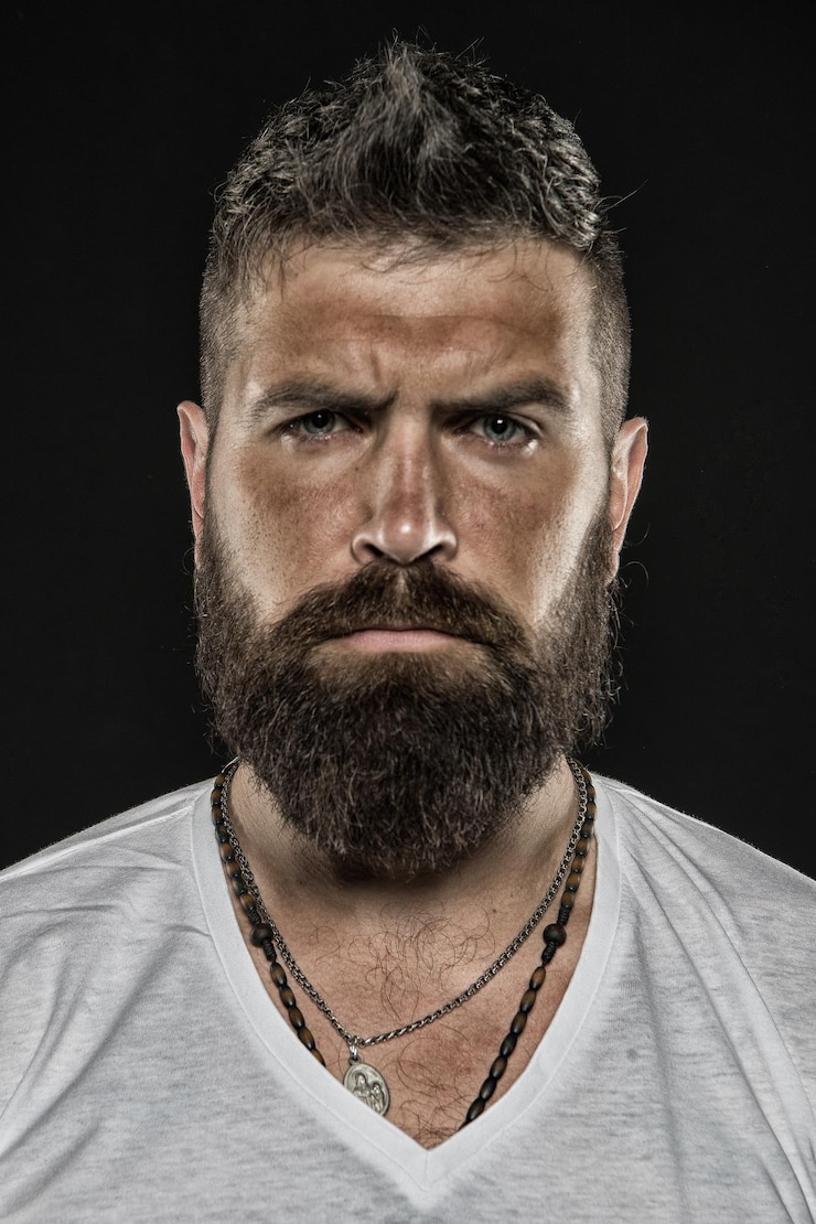 Foto brutalidade e masculinidade homem barbudo hipster rosto sério close-up homem brutal com rosto de pele bronzeada hipster com barba e bigode parece rigoroso e brutal aparência masculina brutal