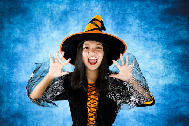 Foto bruxa de halloween com fundo azul escuro. jovem retrato.