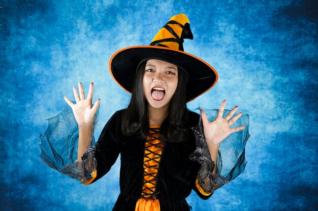 Bruxa de Halloween com fundo azul escuro. Jovem retrato.