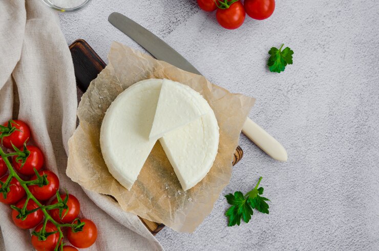 Foto brynza de queijo fresco caseiro ou queijo feta sobre uma tábua de madeira