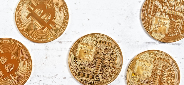Btc conmemorativo dorado - criptomoneda bitcoin - monedas esparcidas en tablero de piedra blanca, detalle de cierre desde arriba