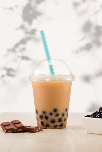 Bubble boba tea com leite e pérolas de tapioca em copo plástico