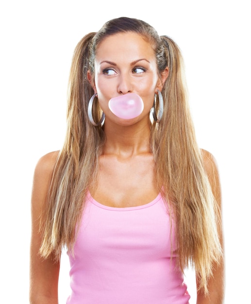 Bubblegum fun Foto de estudio de una hermosa mujer soplando chicle contra un fondo blanco.