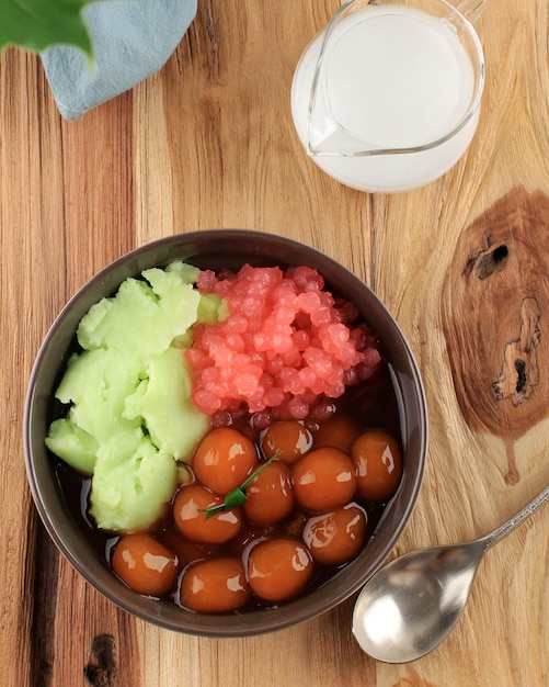 Bubur Campur Madura oder Maduranese-Mix-Brei mit verschiedenen Zutaten Reismehl Congee Kokosmilch Süßkartoffelbällchen Palmzuckersirup und rote Sago-Perle Draufsicht