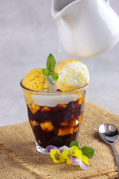 Bubur Ketan Hitam oder schwarzer Klebreisbrei mit Mangoscheibe und Kokosnuss und Mango