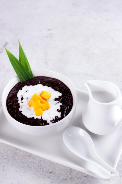 Bubur Ketan Hitam ou mingau de arroz glutinoso preto com molho de leite de coco e cobertura com manga