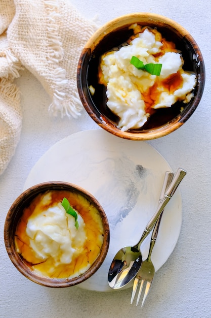 Bubur Sumsum. Mingau de sobremesa javanês de farinha de arroz, leite de coco com xarope de açúcar de palma. Servido em tigela de madeira. Um alimento inicial popular para quebrar o jejum durante o Ramadã.