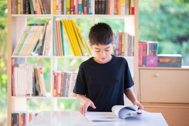 Buch des kleinen Jungen Lesein der Bibliothek