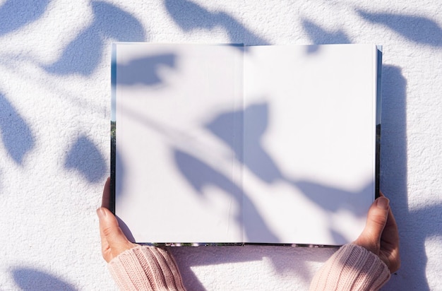 Buch in Händen mit schönem Schatten