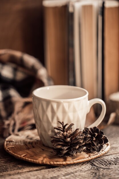 Buch mit Schal und Tasse Tee auf Holzhintergrund