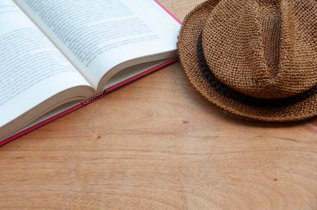 Buch und Hut auf Holztisch mit anpassbarem Platz für Text oder Ideen