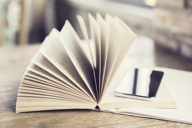 Foto buch und smartphone auf einem holztisch