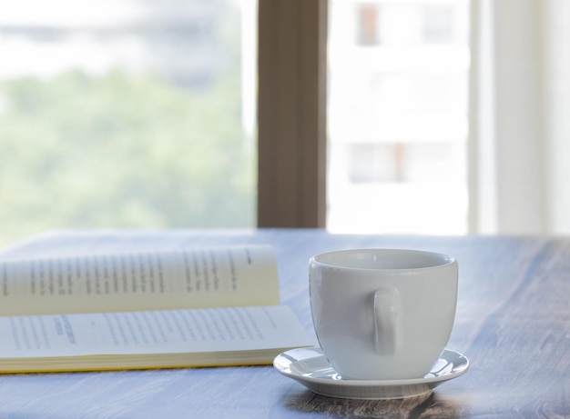 Buchen Sie auf dem Tisch mit einer Tasse Kaffee