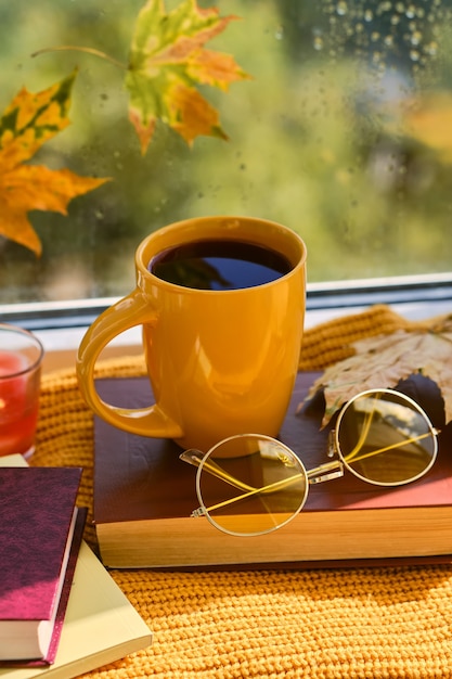 Buchen Sie mit Brille, Tasse Kaffee, Herbstlaub, Wollpullover