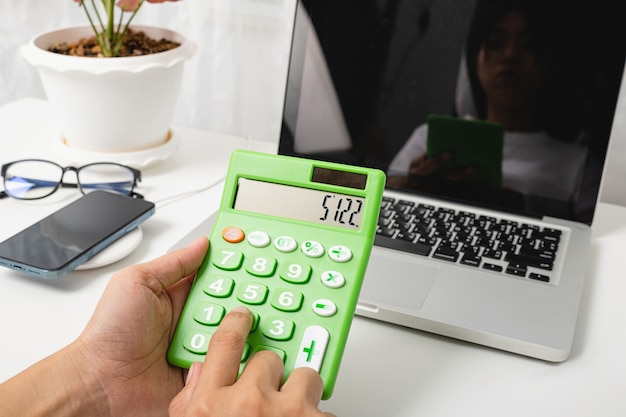 Foto buchhalter, der mit taschenrechner und laptop arbeitet und finanzberechnungen analysiert