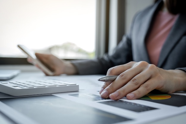 Buchhalterin der Geschäftsfrauen, die Stift hält und Laptop verwendet Konto für die Zahlung der Steuer auf weißen Schreibtisch im Arbeitsbüro.