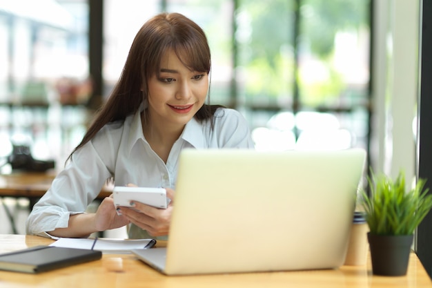 Buchhalterin, die mit Laptop und Taschenrechner im Café-Co-Working-Space arbeitet