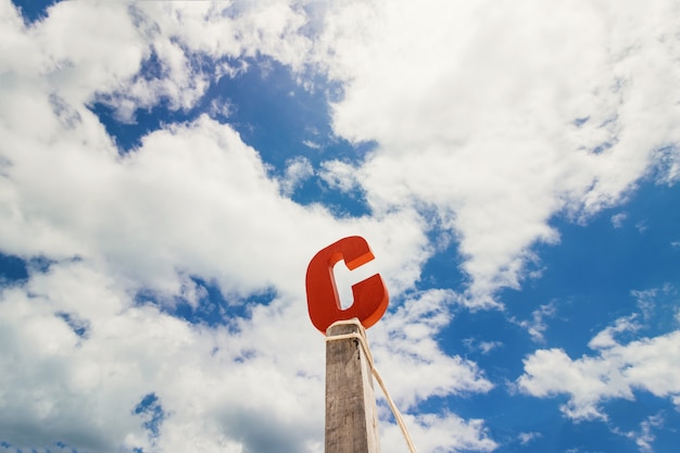 Buchstabe c holz vor blauem wolkenhimmel