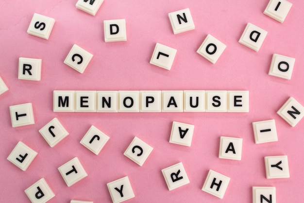 Foto buchstaben des alphabets mit dem wort menopause das konzept der frauenkrankheit gesundheit und medizinische