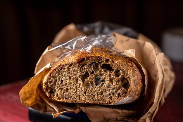 Buchweizenbaguette Geschnittenes Baguette aus dunklem Grobmehl Dunkler Hintergrund