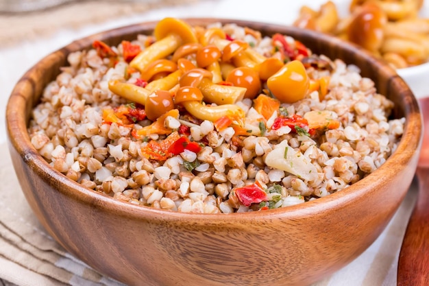 Buchweizenbrei mit Pilzen in einer Holzschale