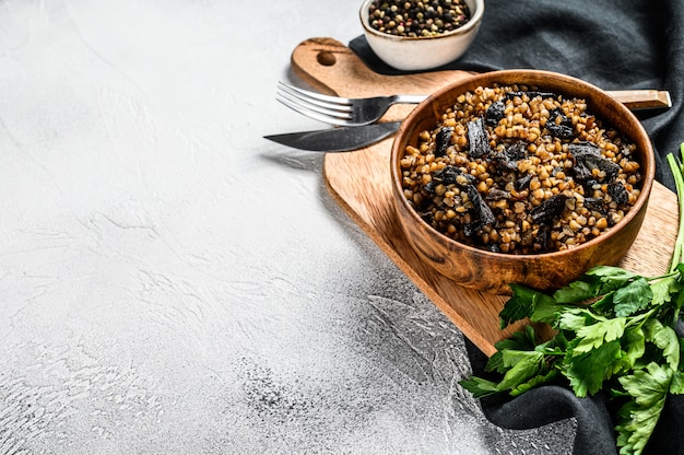 Buchweizenbrei mit Pilzen. Veganes Essen. Russische, ukrainische Küche. Grauer Hintergrund. Draufsicht. Speicherplatz kopieren