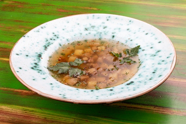 Buchweizensuppe mit Steinpilzen auf farbigem Holzhintergrund Vegetarisches Gericht