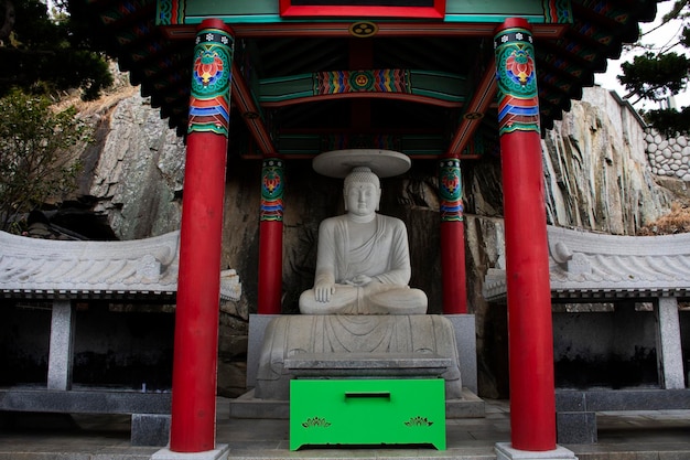 Foto buda de pedra antiga no santuário de yonggung para os viajantes coreanos viajam, visitam e respeitam a bênção de oração, desejam o mistério sagrado no templo de haedong yonggungsa em gijang em busan ou pusan da coreia do sul