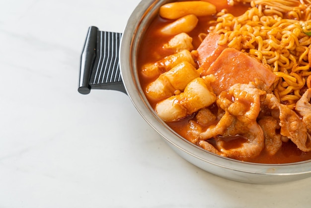 Budae Jjigae oder Budaejjigae (Armeeeintopf oder Armeebasiseintopf). Es ist voll mit Kimchi, Spam, Würstchen, Ramen-Nudeln und vielem mehr – dem beliebten koreanischen Hot-Pot-Food-Stil