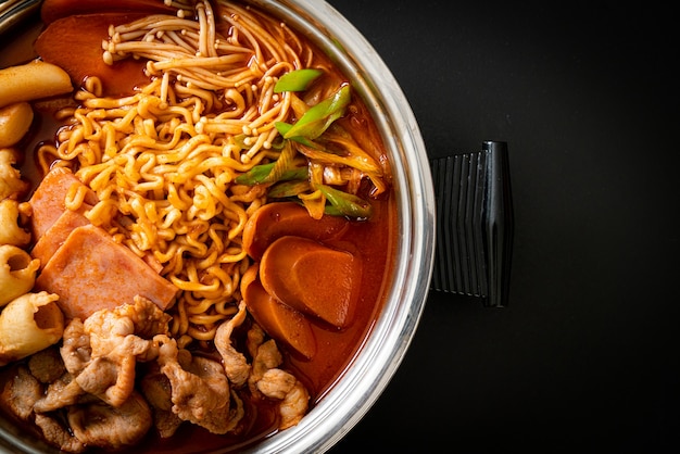 Budae Jjigae oder Budaejjigae (Armeeeintopf oder Armeestützpunkteintopf). Es ist vollgepackt mit Kimchi, Spam, Würstchen, Ramen-Nudeln und vielem mehr - beliebter koreanischer Hot Pot Food Style